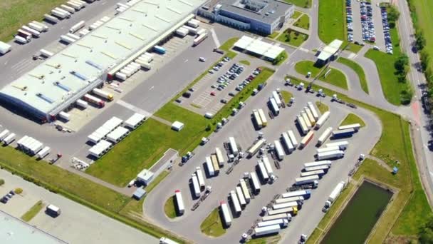 Vue aérienne de l'entrepôt de marchandises. Centre logistique dans la zone industrielle de la ville d'en haut. Vue aérienne du chargement des camions au centre logistique — Video