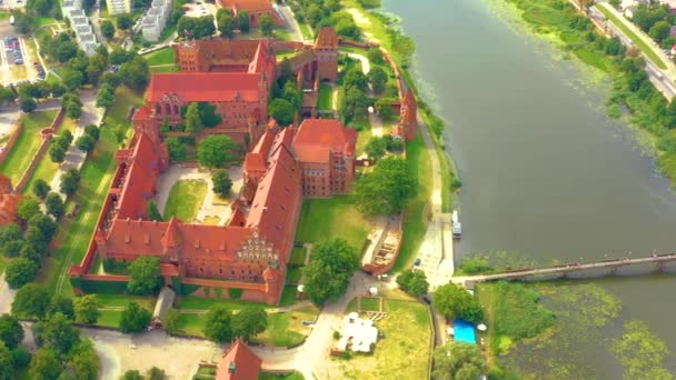 Malbork,Poland.Aerial 4K video from drone to Medieval Malbork ( Zamek w Maborku, Ordensburg Marienburg ),castle in Poland fortress of the Teutonic Knights at the Nogat river in sunrise light.(Series) — Vídeo de stock