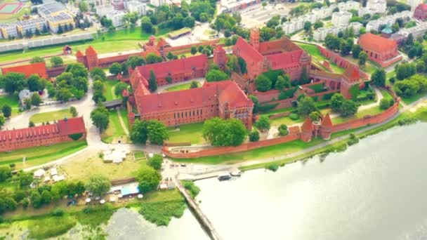 Malbork,Poland.Aerial 4K video from drone to Medieval Malbork ( Zamek w Maborku, Ordensburg Marienburg ),castle in Poland fortress of the Teutonic Knights at the Nogat river in sunrise light.(Series) — Stock Video