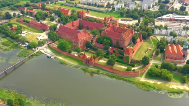 Malbork,Poland.Aerial 4K video from drone to Medieval Malbork ( Zamek w Maborku, Ordensburg Marienburg ),castle in Poland fortress of the Teutonic Knights at the Nogat river in sunrise light.(Series) — ストック動画