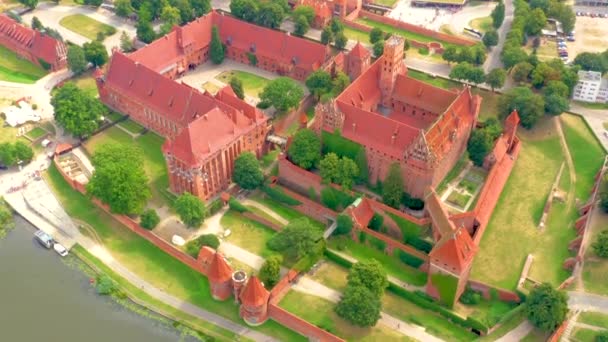 Malbork,Poland.Aerial 4K video from drone to Medieval Malbork ( Zamek w Maborku, Ordensburg Marienburg ),castle in Poland fortress of the Teutonic Knights at the Nogat river in sunrise light.(Series) — Stock Video