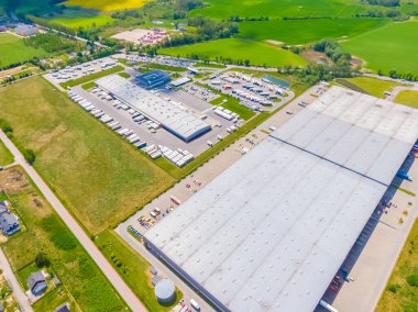 Malzeme deposunun havadan görüntüsü. Sanayi bölgesindeki lojistik merkezi yukarıdan. Lojistik merkezde yüklenen kamyonların hava görüntüsü