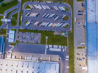 Malzeme deposunun havadan görüntüsü. Sanayi bölgesindeki lojistik merkezi yukarıdan. Lojistik merkezde yüklenen kamyonların hava görüntüsü