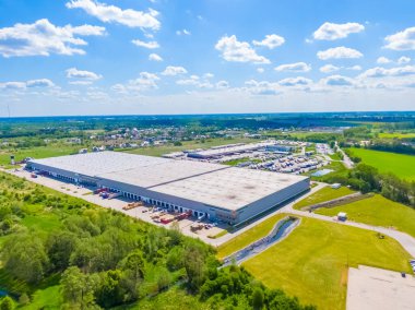 Deposu olan bir lojistik parkının hava görüntüsü, yükleme merkezi ve yükleme / boşaltma için rampalarda bekleyen bir sürü kargo karavanı olan kamyonlar.