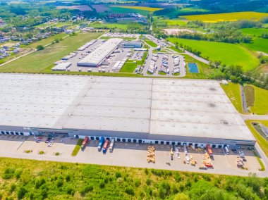 Malzeme deposunun havadan görüntüsü. Sanayi bölgesindeki lojistik merkezi yukarıdan. Lojistik merkezde yüklenen kamyonların hava görüntüsü