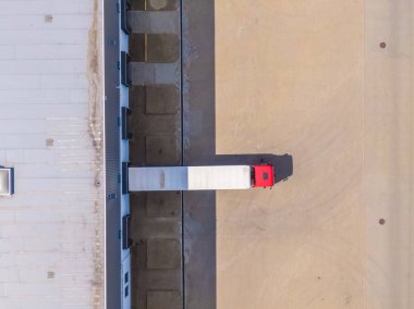 Malzeme deposunun havadan görüntüsü. Sanayi bölgesindeki lojistik merkezi yukarıdan. Lojistik merkezde yüklenen kamyonların hava görüntüsü