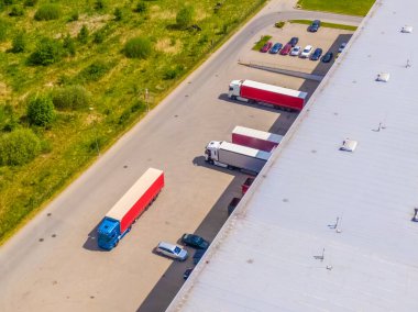 Malzeme deposunun havadan görüntüsü. Sanayi bölgesindeki lojistik merkezi yukarıdan. Lojistik merkezde yüklenen kamyonların hava görüntüsü