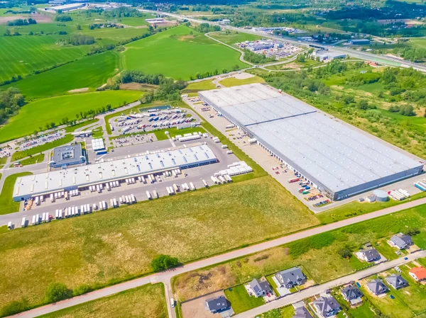 Malzeme deposunun havadan görüntüsü. Sanayi bölgesindeki lojistik merkezi yukarıdan. Lojistik merkezde yüklenen kamyonların hava görüntüsü