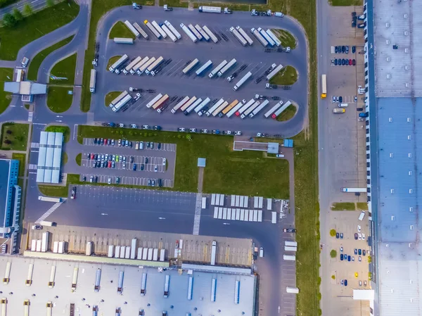 Malzeme deposunun havadan görüntüsü. Sanayi bölgesindeki lojistik merkezi yukarıdan. Lojistik merkezde yüklenen kamyonların hava görüntüsü