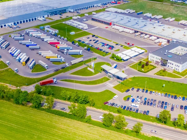 Malzeme deposunun havadan görüntüsü. Sanayi bölgesindeki lojistik merkezi yukarıdan. Lojistik merkezde yüklenen kamyonların hava görüntüsü