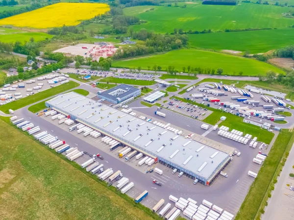 Terminaldeki renkli kamyonların hava görüntüsü boşaltılmayı bekliyor. Lojistik merkezinin üst görüntüsü. Ulaşım. Nakliye, teslimat. Uluslararası karayolu taşımacılığı.