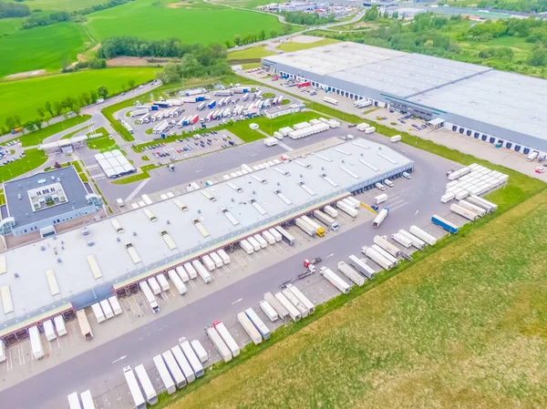 Terminaldeki renkli kamyonların hava görüntüsü boşaltılmayı bekliyor. Lojistik merkezinin üst görüntüsü. Ulaşım. Nakliye, teslimat. Uluslararası karayolu taşımacılığı.