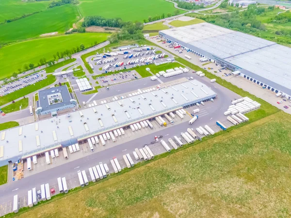 Terminaldeki renkli kamyonların hava görüntüsü boşaltılmayı bekliyor. Lojistik merkezinin üst görüntüsü. Ulaşım. Nakliye, teslimat. Uluslararası karayolu taşımacılığı.