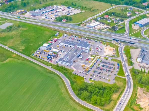 Deposu olan bir lojistik parkının hava görüntüsü, yükleme merkezi ve yükleme / boşaltma için rampalarda bekleyen bir sürü kargo karavanı olan kamyonlar.