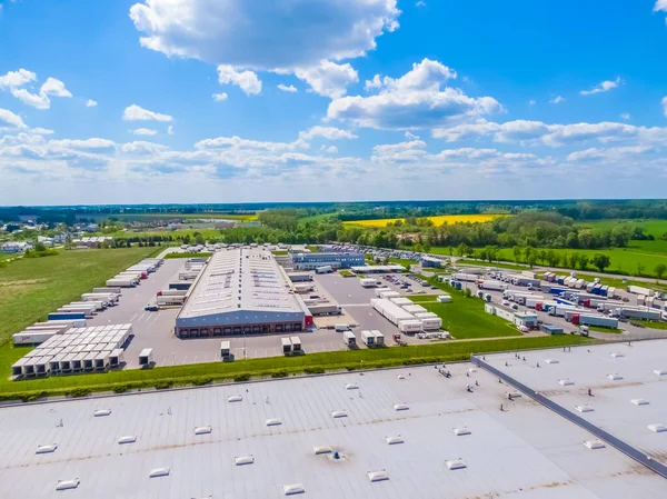 Malzeme deposunun havadan görüntüsü. Sanayi bölgesindeki lojistik merkezi yukarıdan. Lojistik merkezde yüklenen kamyonların hava görüntüsü