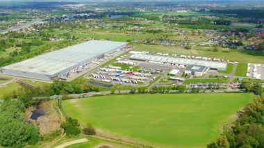 Yarı römorklu kamyonlar lojistik parkının otoparkında durup gün batımında depo rampalarında yükleme ve boşaltma için bekliyorlar. Hava görünümü