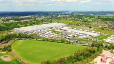 Yarı römorklu kamyonlar lojistik parkının otoparkında durup gün batımında depo rampalarında yükleme ve boşaltma için bekliyorlar. Hava görünümü