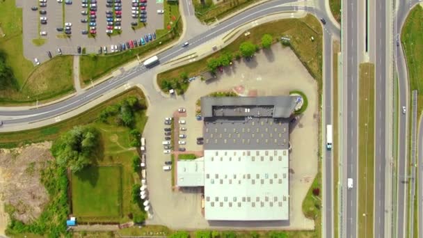 Aerial top down view of the big logistics park with warehouses, loading hub and a lot of semi trucks with cargo trailers awaiting for loading/unloading goods on ramps — Stockvideo