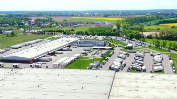 Edificios de centro logístico, almacenes cerca de la carretera, proceso de estacionamiento de camiones, vista desde la altura, un gran número de camiones en el estacionamiento cerca del almacén. — Vídeo de stock
