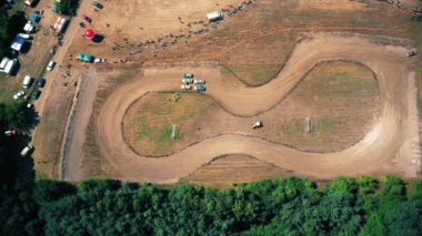 Otomotiv spor müsabakaları. Spor arabalar yarışıyor. Geleneksel rali. Yarış arabası dik bir viraja girer, etrafa saçılır, toz püskürtülür. Aşırı bir miting. Hava görünümü