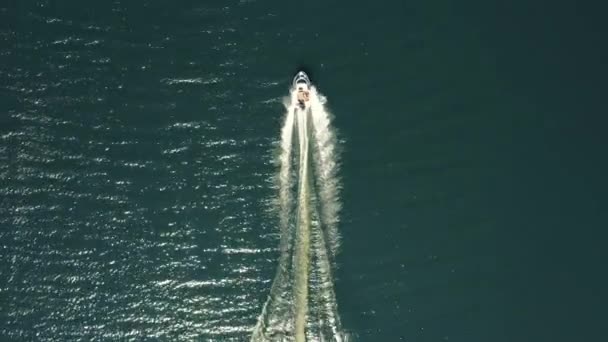 浅色豪华船艇 在蓝色水面上快速航行 空中观景 豪华豪华的意大利船在水面上颠簸 船用黑木 在水面上移动 — 图库视频影像