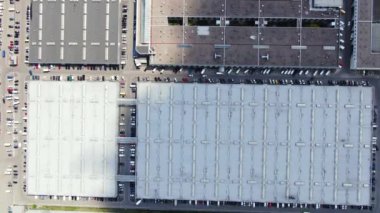Aerial footage of a large shopping centre and car parks located in the city