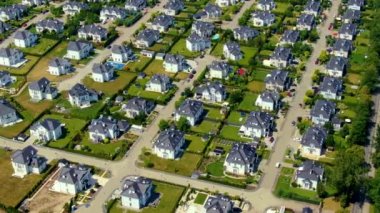 Bahar mevsiminde yeni evleri olan bir sokak. Tek kişilik aile evleri ve planlanmış inşaat alanları. Arka bahçeden ön tarafa kadar uzanan hava araçların geçtiğini gösteriyor..