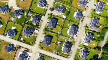 Bahar mevsiminde yeni evleri olan bir sokak. Tek kişilik aile evleri ve planlanmış inşaat alanları. Arka bahçeden ön tarafa kadar uzanan hava araçların geçtiğini gösteriyor..