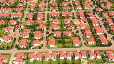 Aerial drone footage over the summer street. Modern luxury houses. Aerial flying over the residential area. Asphalt roads and sidewalks. Red roof