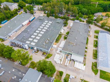 Malzeme deposunun havadan görüntüsü. Sanayi bölgesine yukarıdan lojistik merkezi teslimatı. Lojistik merkezde yüklenen kamyonların hava görüntüsü