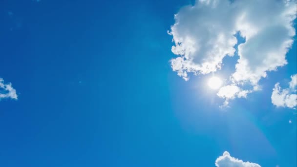 明るい太陽の光の線のフレア太陽の光は 熱帯の夏の日差しの中で美しい晴れたパステルブルーの空にカラフルな暗い積雲を通して輝く太陽の光の日 4Kロールタイムラプス — ストック動画