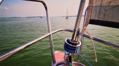 Mavi gökyüzü ve deniz altyapısı olan beyaz bir yelkenlinin ön yayı. Ufuktaki adalar ve bulutlar. Kopyalama alanı olan mavi bir aşk.