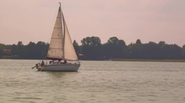 Muhteşem günbatımında denizde yüzen bir tekne. Lüks yat ve deniz gezisi tatili.