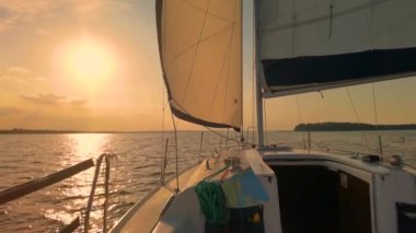 Muhteşem günbatımında denizde yüzen bir tekne. Lüks yat ve deniz gezisi tatili.