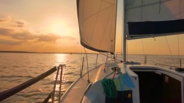 Günbatımı ve deniz altyapısı olan beyaz bir yelkenlinin ön pruvası. Ufuktaki adalar ve bulutlar. Kopyalama alanı olan mavi bir aşk.