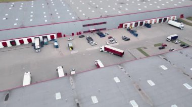 Depo rampalarında durmakta olan kargo römorklu bir tırın hava görüntüsü. Yükleme merkezli büyük lojistik parkındaki malları yüklemek / boşaltmak için.