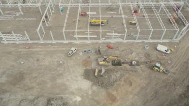 Çeşitli Mühendisler ve Mimarlar Mühendislik ve Mimarlar Mühendislik Projelerini Tartışan Yeni Yapılandırma Geliştirme Alanının Üzerinde Hava Uçuşu. Bölgede Ağır Makineler ve İnşaat İşçileri Çalışıyor.