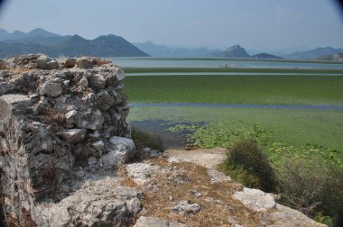 Karadağ 'daki Skadar Gölü. Doğanın ve dağların zenginliğiyle gölün açık yüzeyi. Gölde tekne turu.
