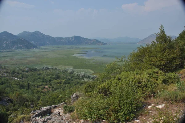 Karadağ 'daki Skadar Gölü. Doğanın ve dağların zenginliğiyle gölün açık yüzeyi. Gölde tekne turu.