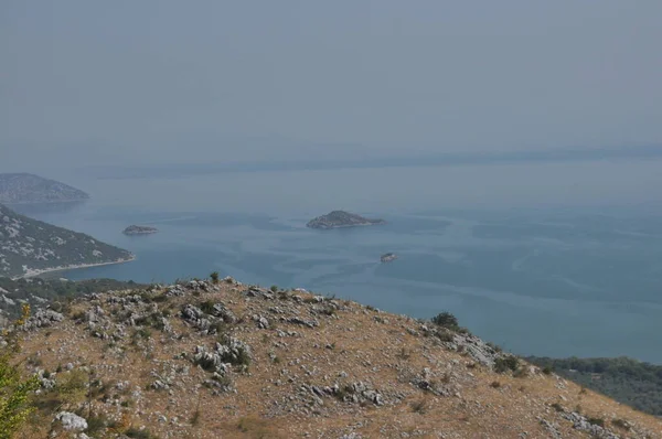 Karadağ 'daki Skadar Gölü. Doğanın ve dağların zenginliğiyle gölün açık yüzeyi. Gölde tekne turu.