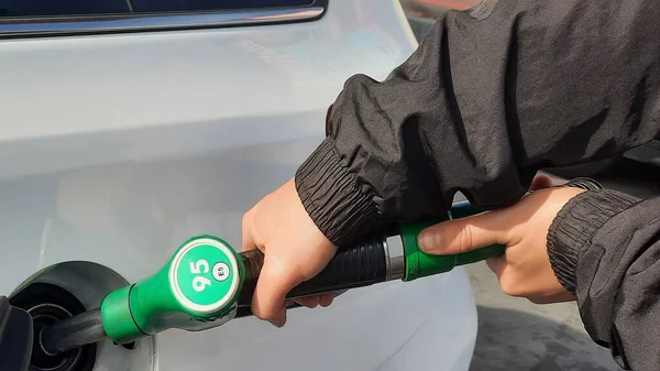 Person refueling gasoline in his vehicle before leaving for a trip