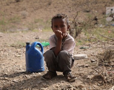 Taiz Yemen - 18 Şubat 2022: Taiz, Yemen 'deki savaştan sürülenler için kamplarda su arayan üzgün bir çocuk görülüyor 