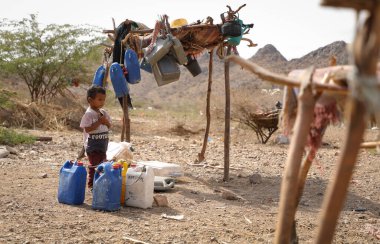 Taiz Yemen - 18 Şubat 2022: Taiz, Yemen 'deki savaştan sürülenler için kamplarda su arayan üzgün bir çocuk görülüyor 