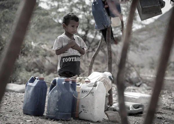 Taiz Yemen - 18 Şubat 2022: Taiz, Yemen 'deki savaştan sürülenler için kamplarda su arayan üzgün bir çocuk görülüyor 