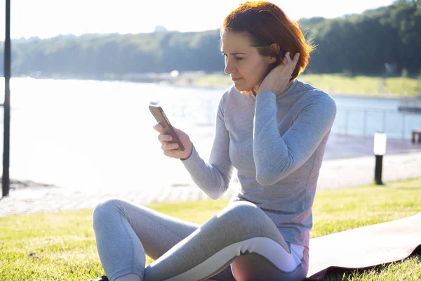 Стройная Рыжая Женщина Спортивной Одежде Мобильного Телефона Парке Здоровье Здоровье — стоковое фото