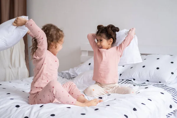 Duas Crianças Meninas Pijama Tendo Travesseiro Luta Cama Moderno Apartamento — Fotografia de Stock