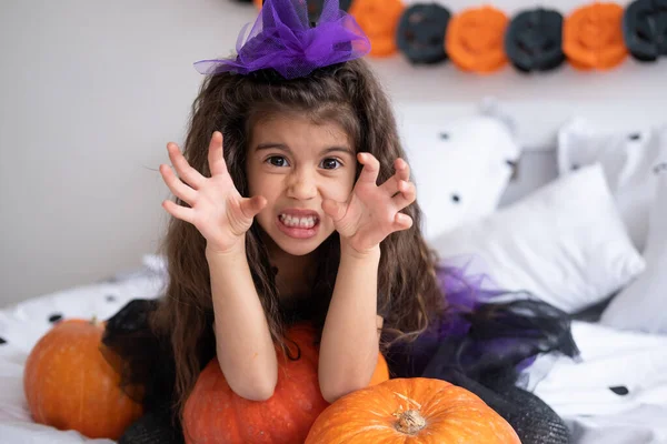 Engraçada menina criança árabe em traje de bruxa se divertindo em decorado para o quarto de Halloween — Fotografia de Stock