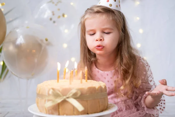 Menina bonito soprando velas no bolo de aniversário e celebrando aniversário — Fotografia de Stock