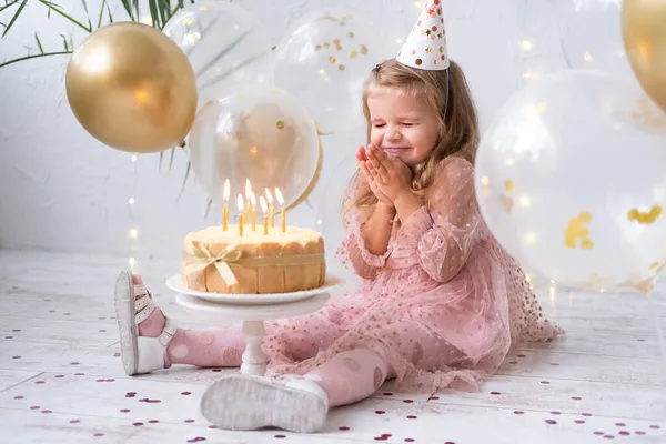 Linda niña soplando velas en pastel de cumpleaños y celebrando cumpleaños —  Fotos de Stock