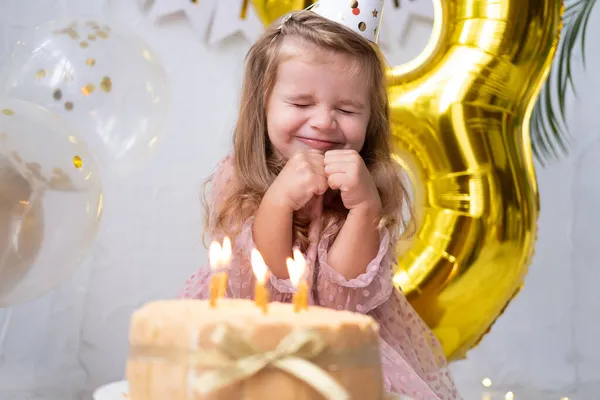 Carina bambina che soffia candele sulla torta di compleanno e festeggia il compleanno — Foto Stock